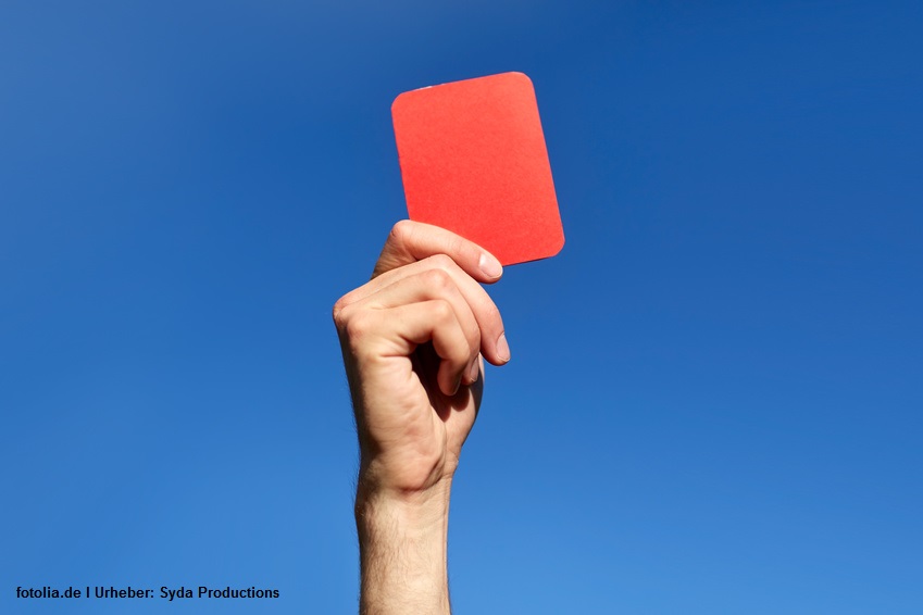referee hands with red card on football field