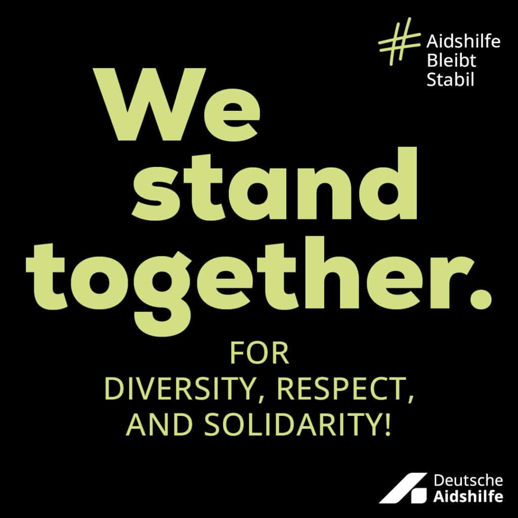 Black campaign motif with the English inscription „We stand together. For diversity, respect, and solidarity.“