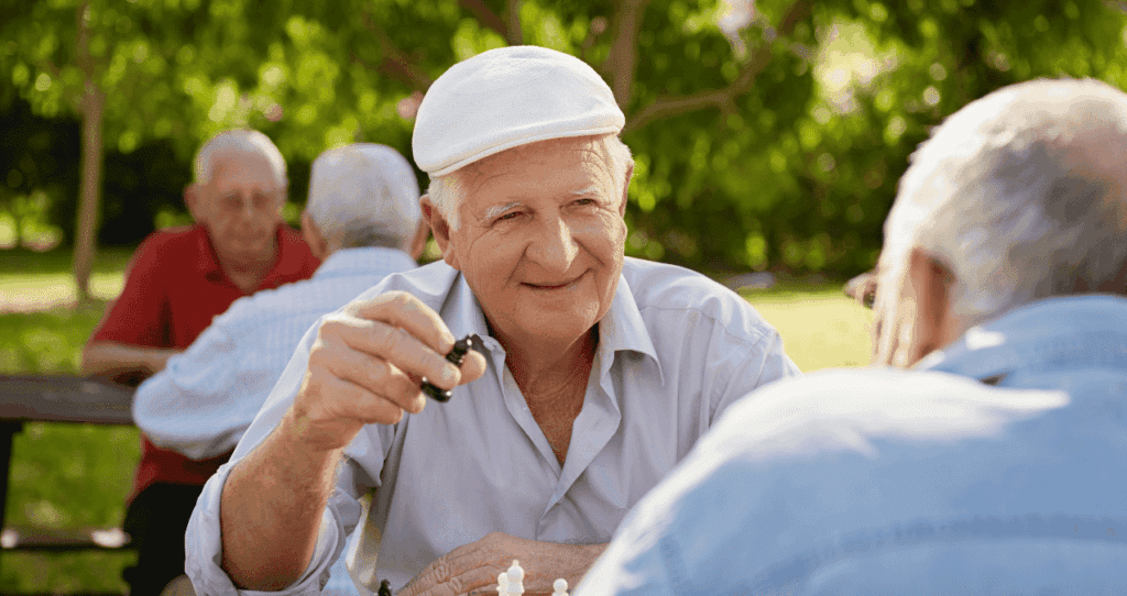 Ältere Männer spielen Schach im Park und genießen die gemeinsame Zeit.