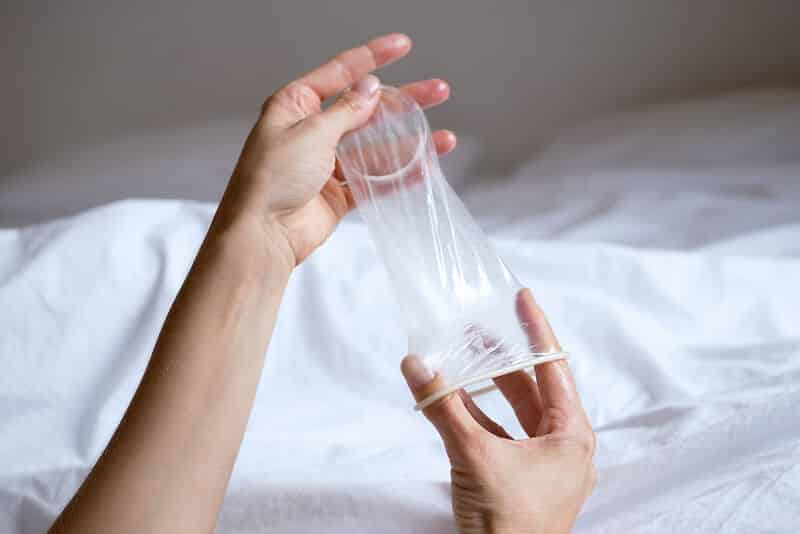 Hände halten ein Femidom (Kondom für Frauen und trans Personen)