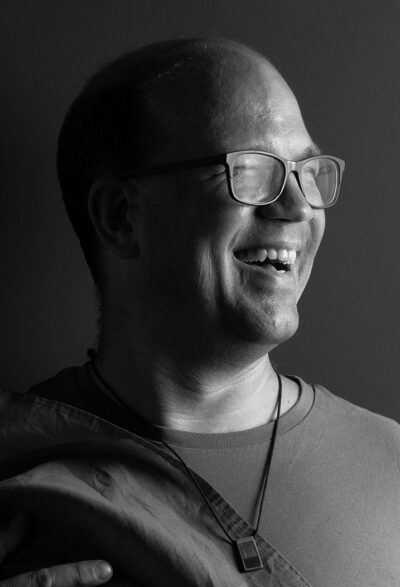 Frank Thies lächelt in die Kamera – Porträt eines bisexuellen Lehrers und Aktivisten.