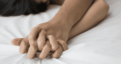 Zwei Männer halten sich beim Sex an den Händen – Symbolbild für Nähe, Vertrauen und Intimität.