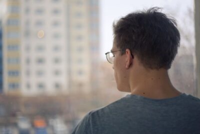 Danilo gazes thoughtfully out of the window of his flat at a high-rise housing estate in Berlin.