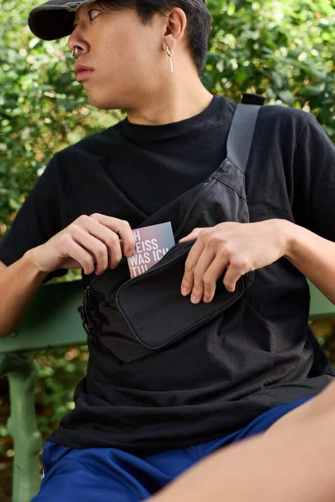 Person with shoulder bag carrying condoms for safer sex and protection against HIV and STIs