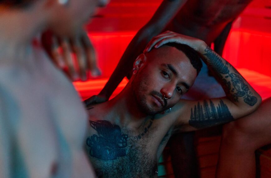 Thoughtful man in red light - symbolic image of porn, porn consumption and sexuality.