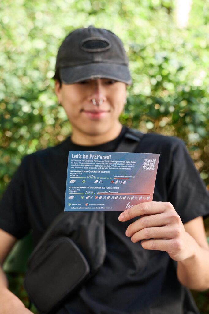 Person hält eine Informationskarte zur HIV-Prävention und PrEP in der Hand