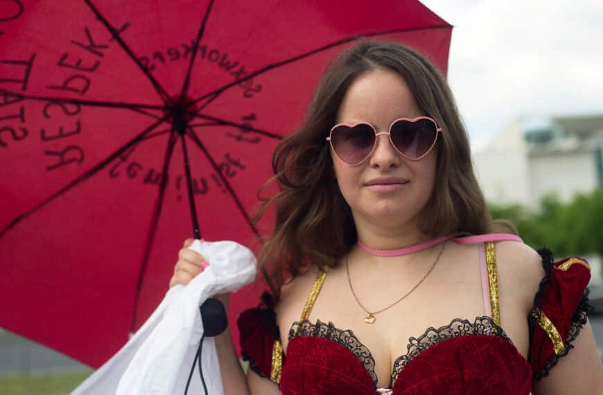 Demonstrierende Sexarbeiterin mit rotem Regenschirm bei einer Aktion in Berlin.