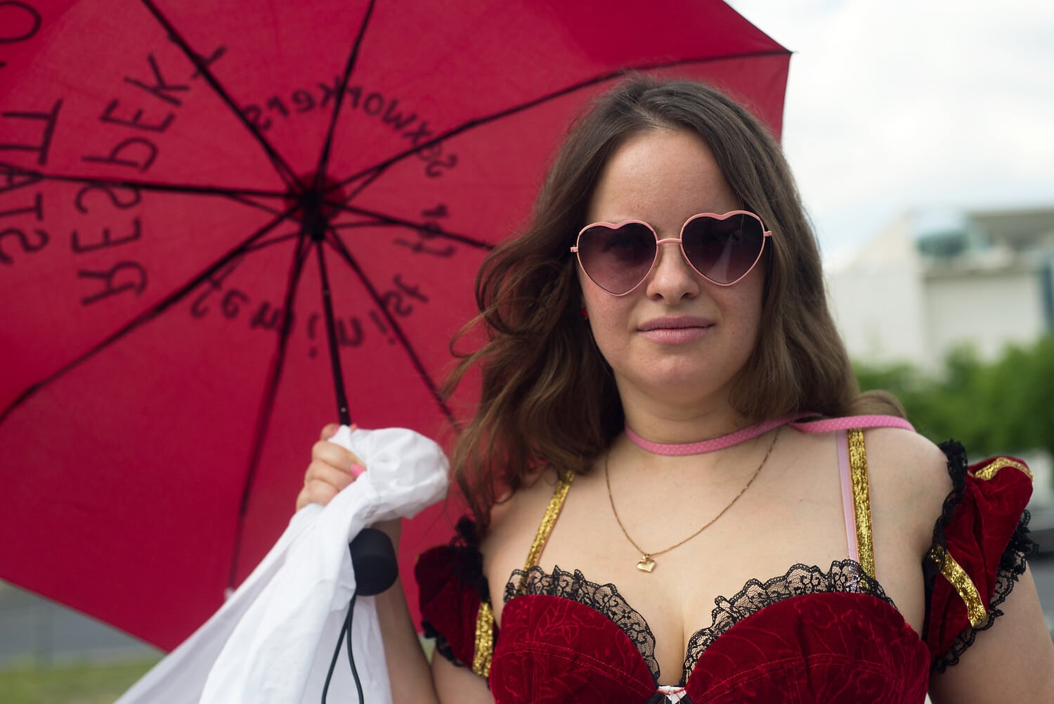 Demonstrierende Sexarbeiterin mit rotem Regenschirm bei einer Aktion in Berlin.